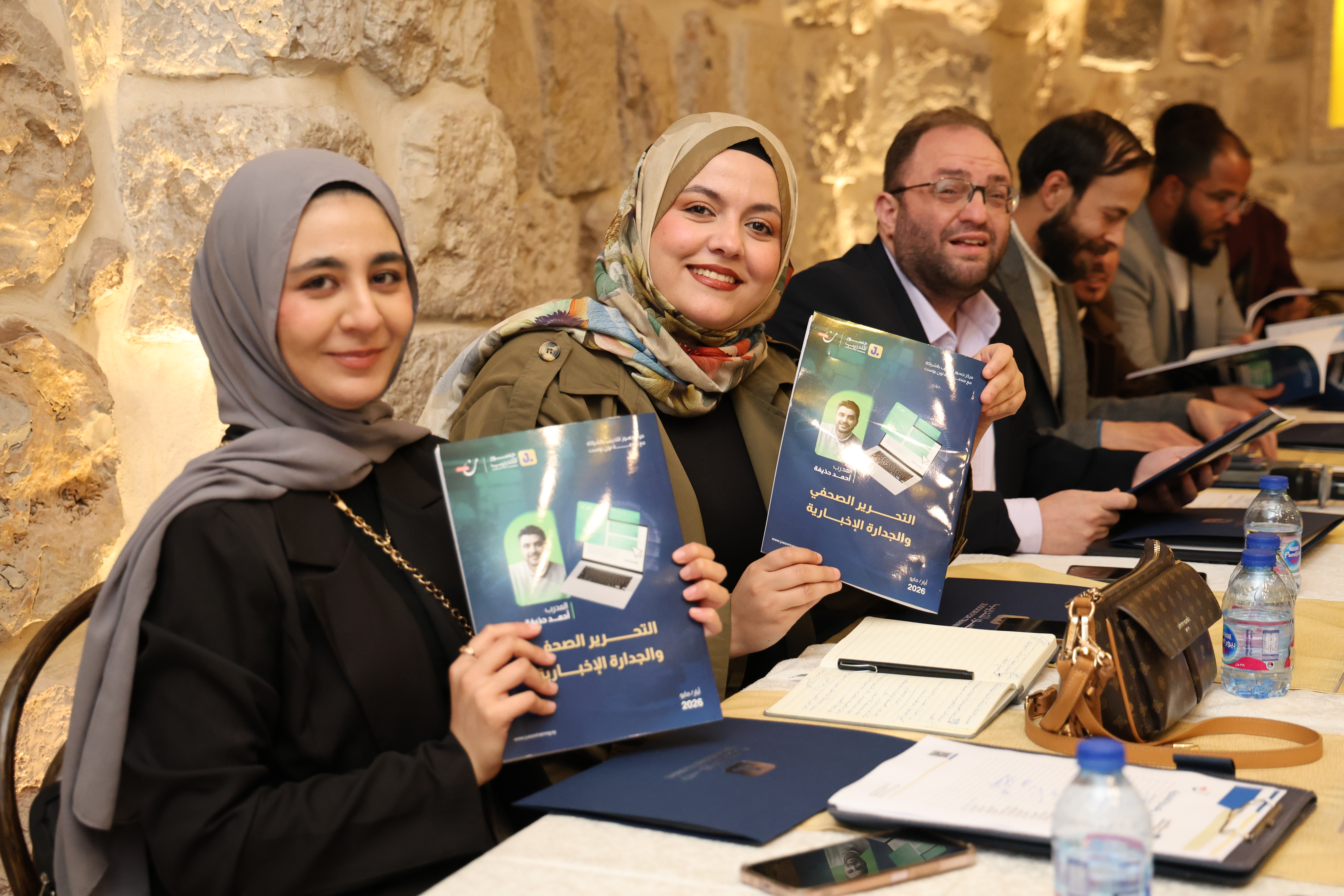 مشاركون يحملون مواد تدريبية في الصحافة